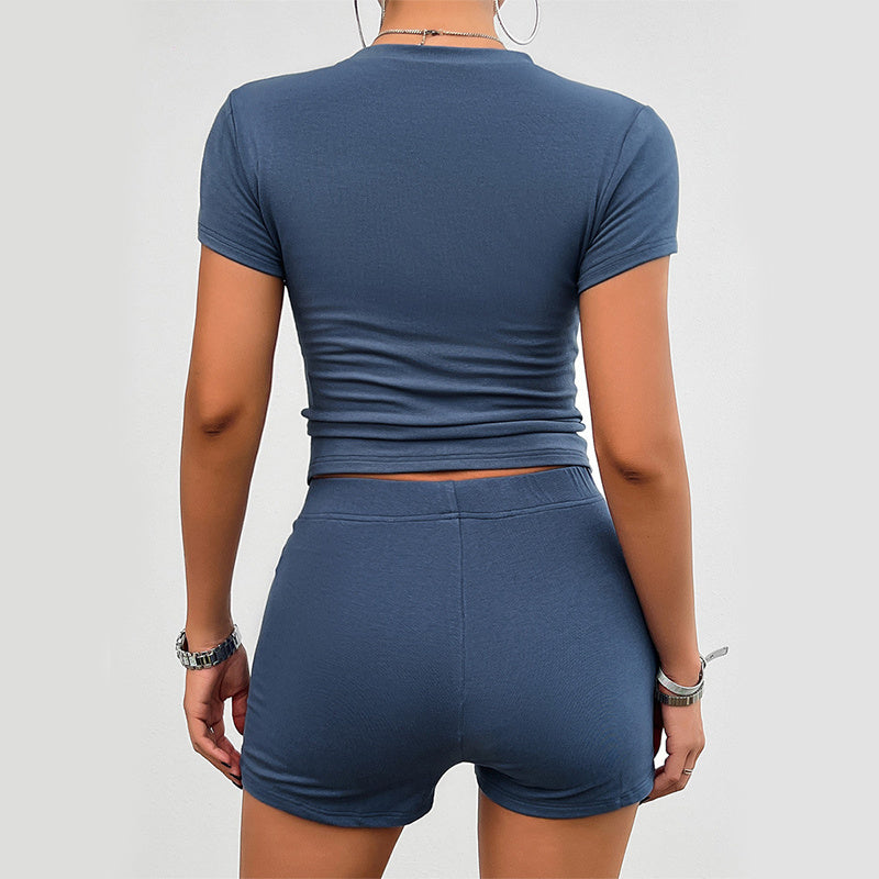 Back view of a woman wearing a blue solid color slim sports suit, featuring a short-sleeved round neck t-shirt and high-waist elastic shorts, fashion womens clothing.